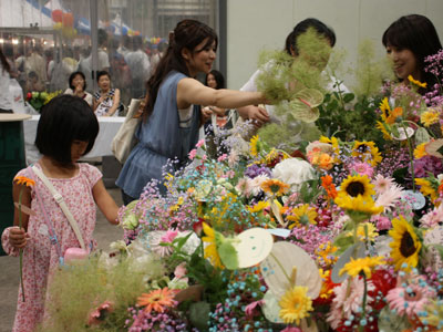 復興への想い込め、多くの人々が「フラワードーナツ」に花を挿す