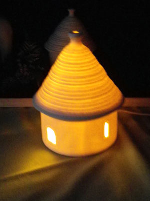 試作品・丸い小屋のオブジェは、内部の豆電球を灯すと暖かなオレンジ色の光がもれる