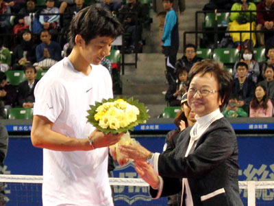 優勝した江原弘泰選手(左)にビクトリーブーケを贈る